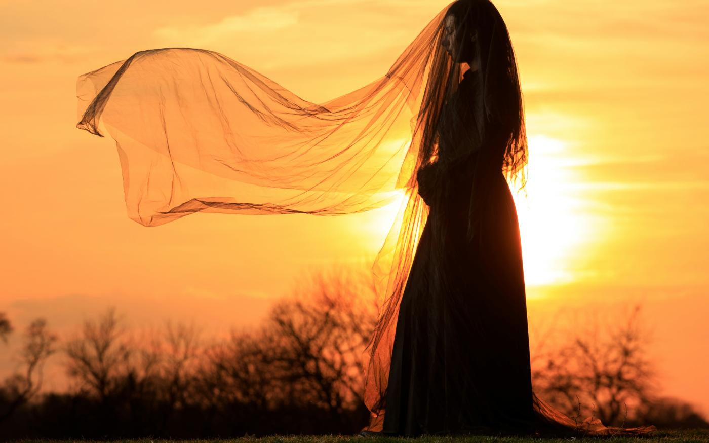 a woman in a long dress with a veil over her head by benjamin lehman courtesy of Unsplash.