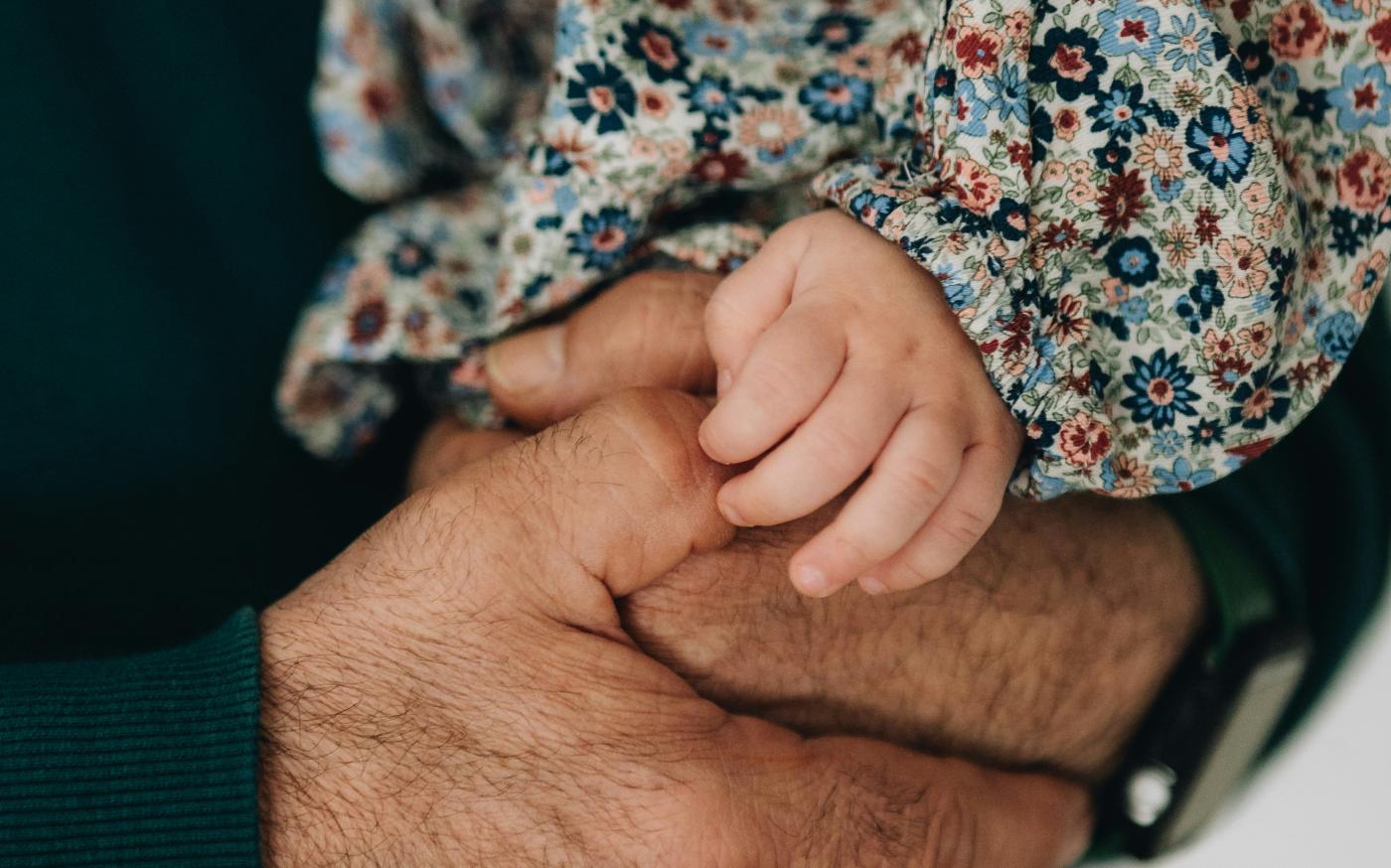 a close up of a person holding a baby by serjan midili courtesy of Unsplash.