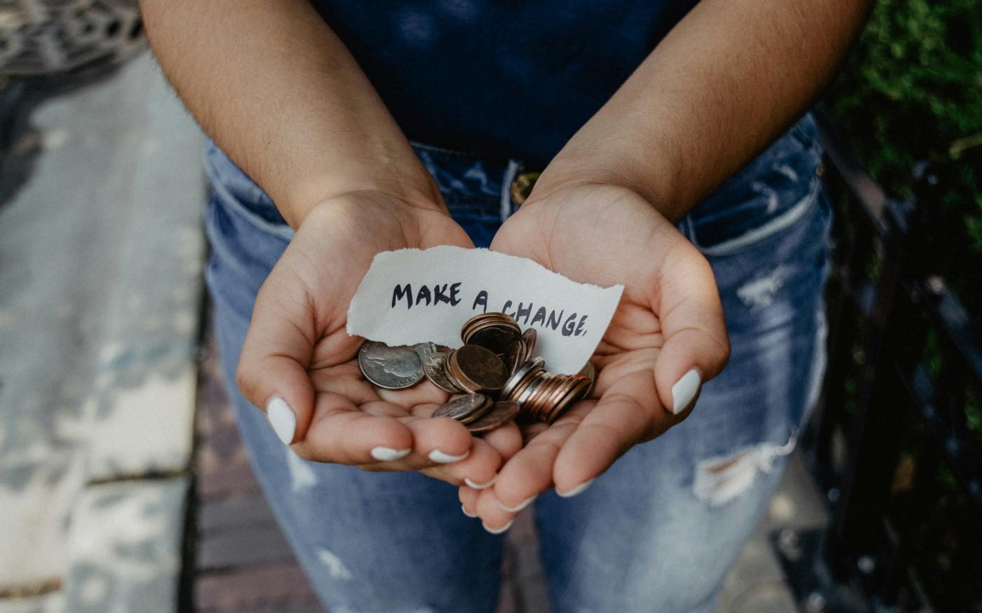 person showing both hands with make a change note and coins by Katt Yukawa courtesy of Unsplash.