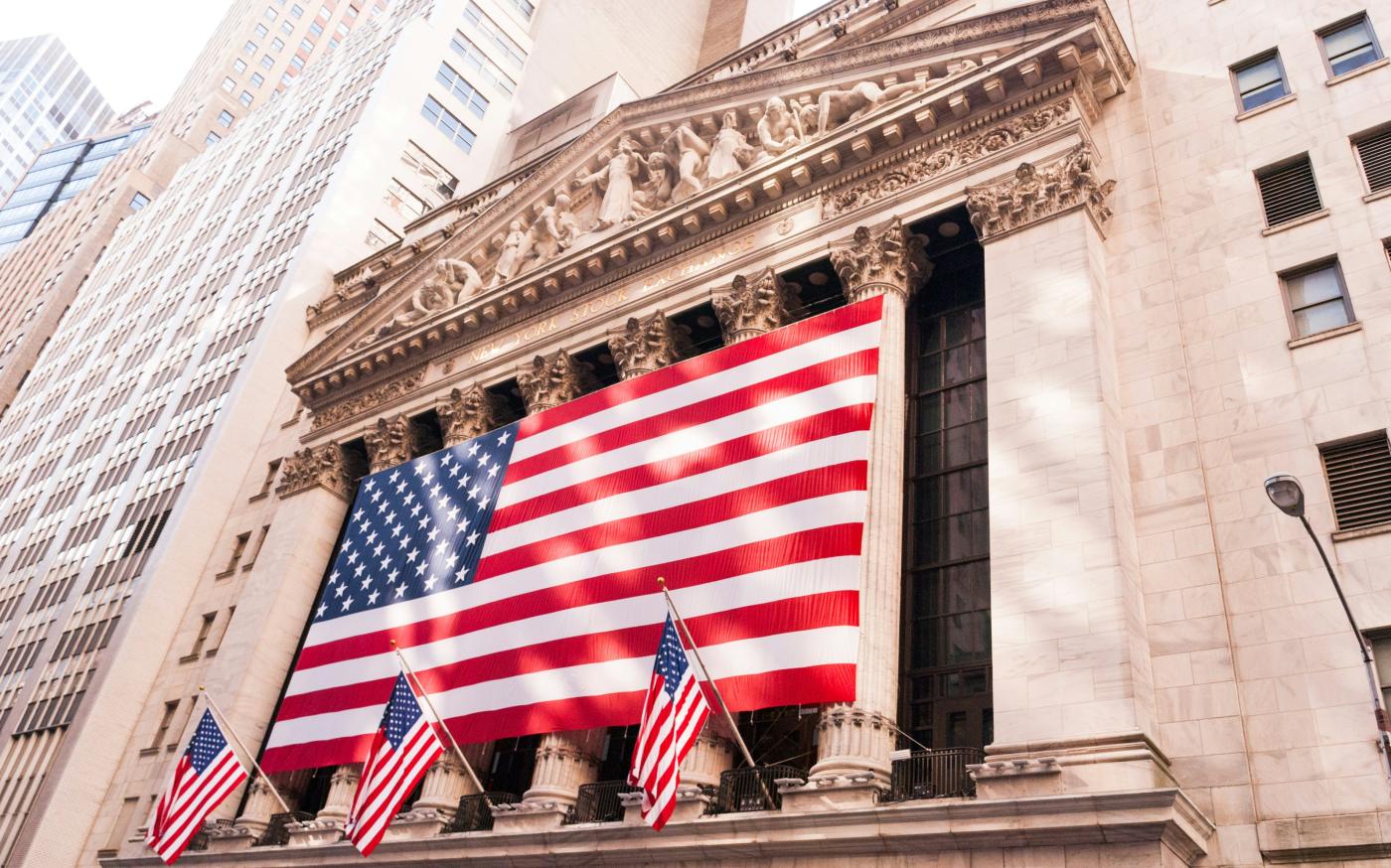 us a flag on top of building by David Vives courtesy of Unsplash.