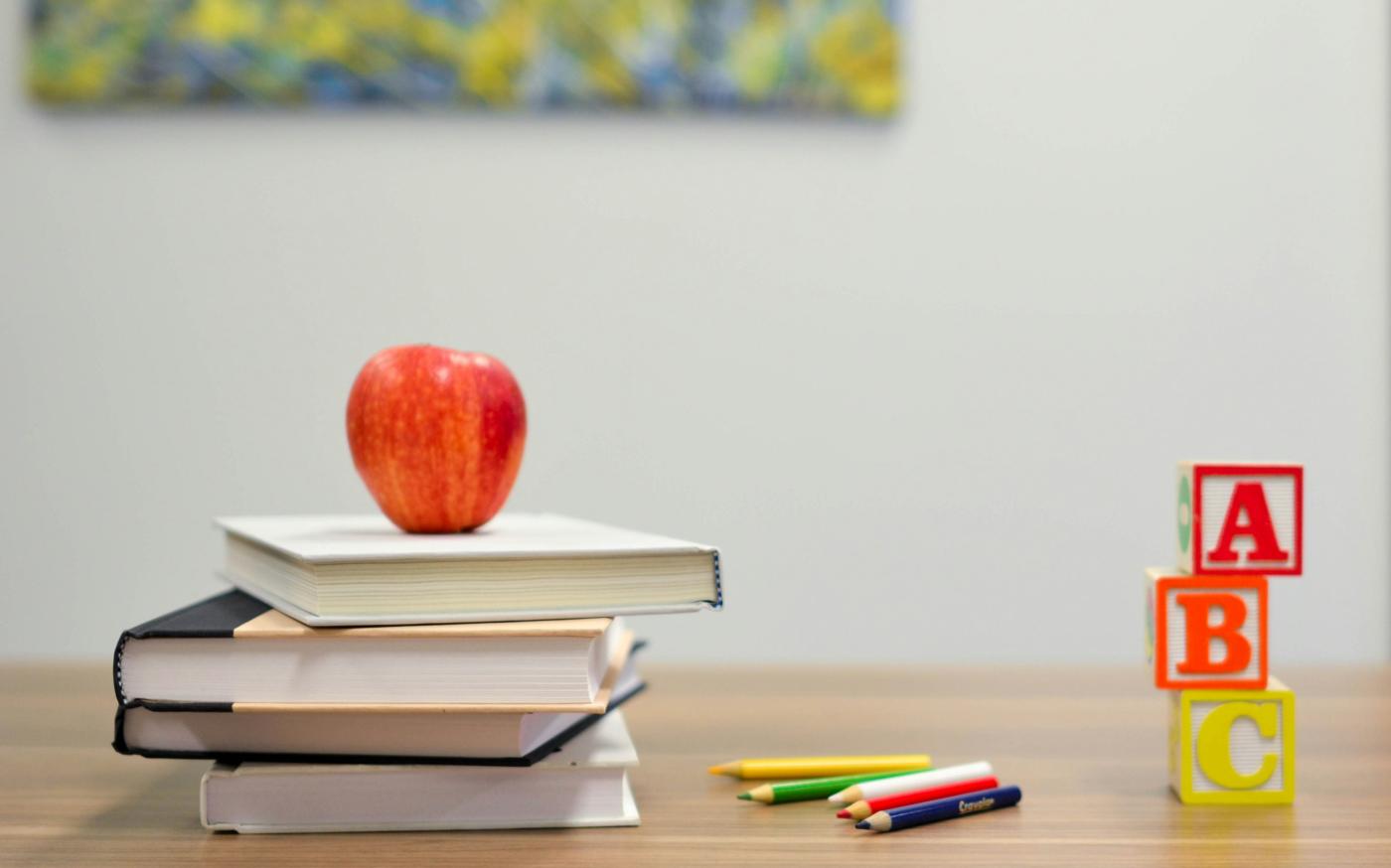 red apple fruit on four pyle books by Element5 Digital courtesy of Unsplash.