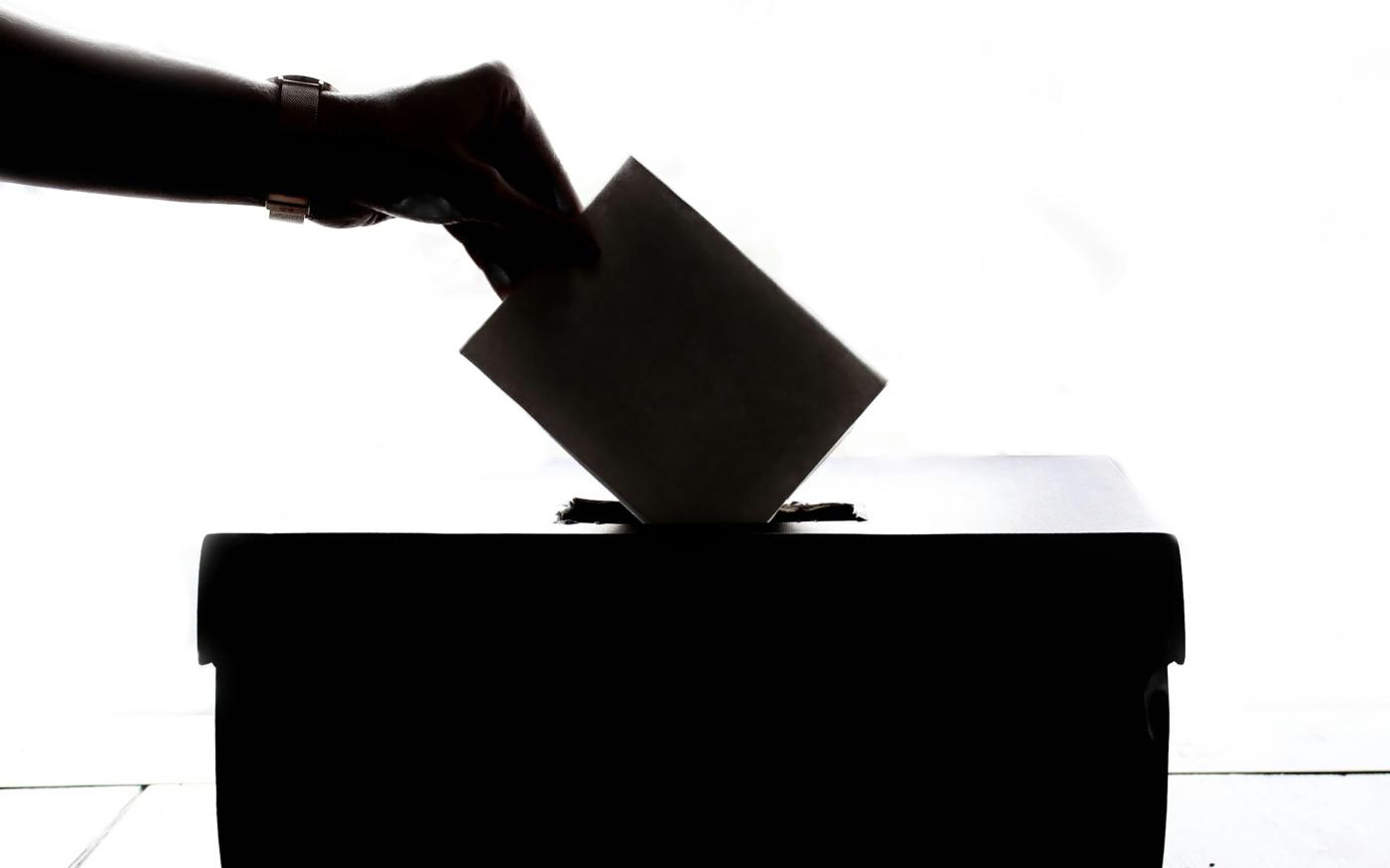 a person is casting a vote into a box by Element5 Digital courtesy of Unsplash.