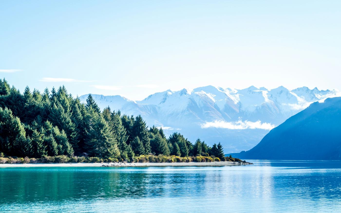 lake surrounded by trees and mountain during daytime by Photoholgic courtesy of Unsplash.