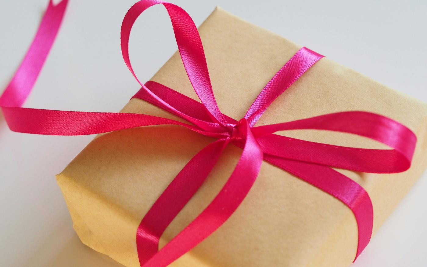 brown gift box with pink ribbon by Jess Bailey courtesy of Unsplash.