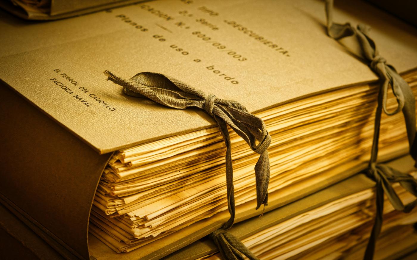 A stack of books with a bow on top of it by Eric Prouzet courtesy of Unsplash.