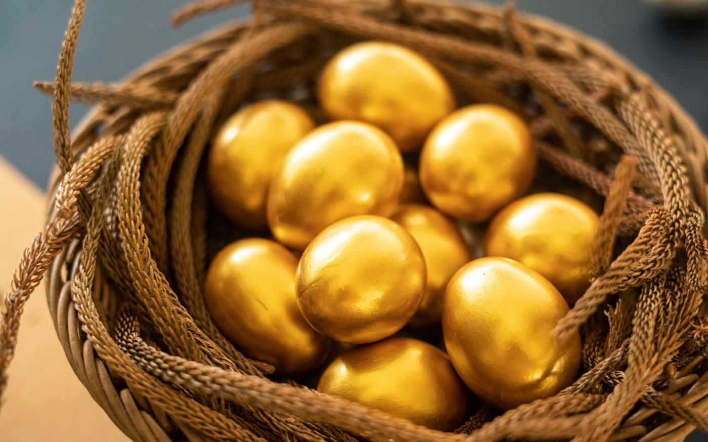a basket filled with gold colored eggs on top of a table by COARSE + FINE courtesy of Unsplash.