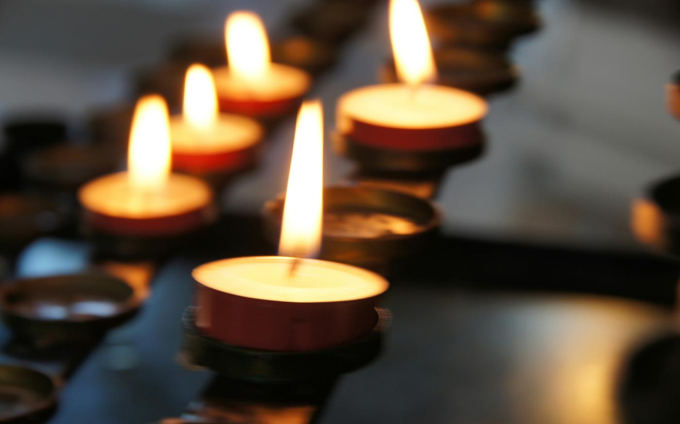 lighted candles on black metal candle holder by Eli Solitas courtesy of Unsplash.