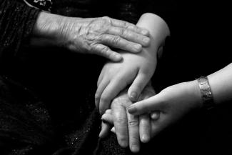 a black and white photo of two people holding hands by razi pouri courtesy of Unsplash.
