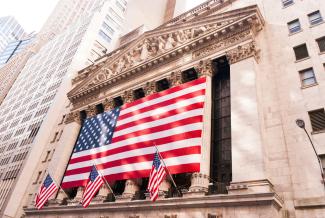 us a flag on top of building by David Vives courtesy of Unsplash.