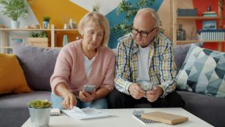 Elderly couple looking at bills and phone by Vitaly Gariev courtesy of Unsplash.