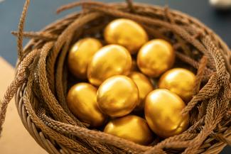 a basket filled with gold colored eggs on top of a table by COARSE + FINE courtesy of Unsplash.